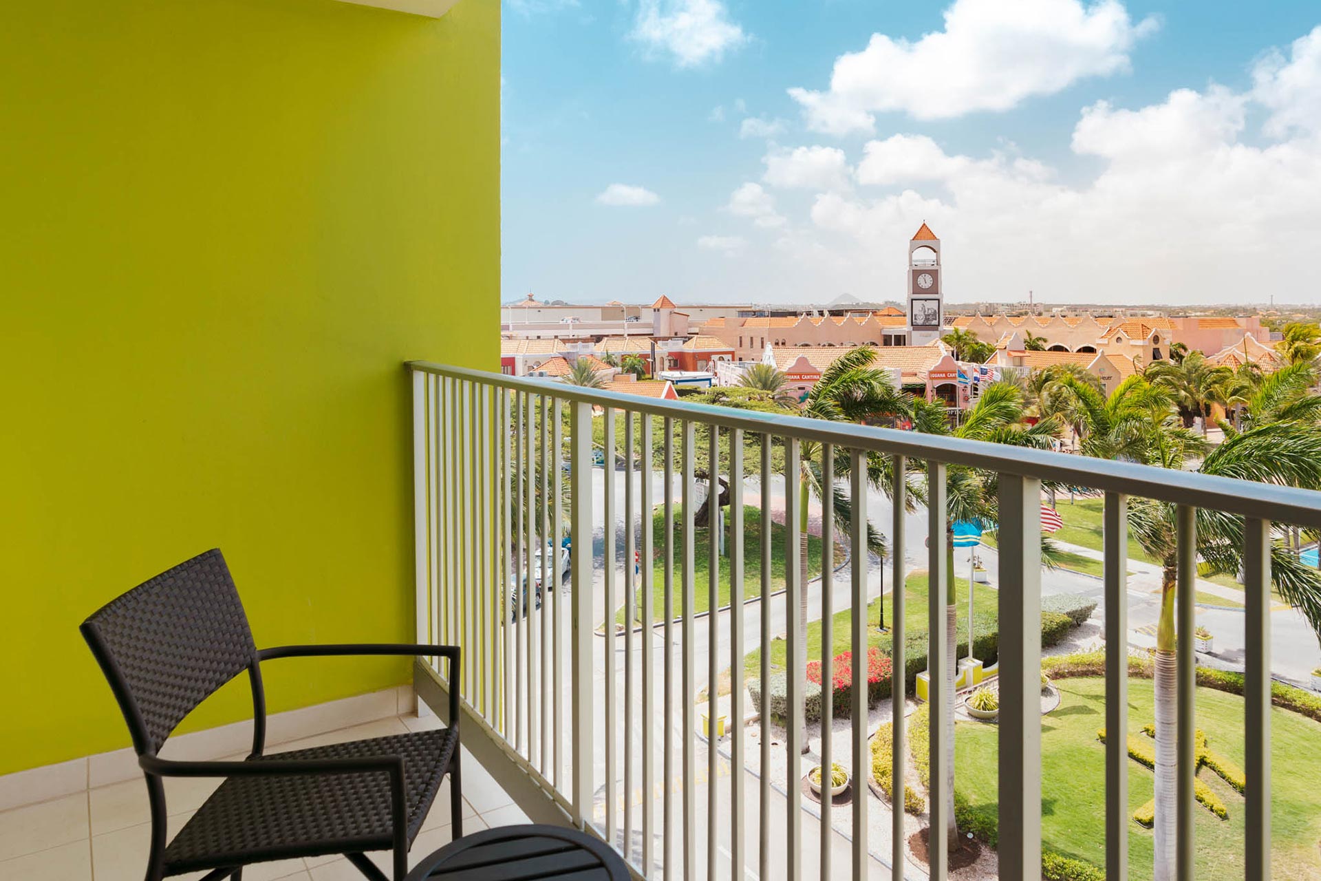 A balcony with a chair and a view of the resort